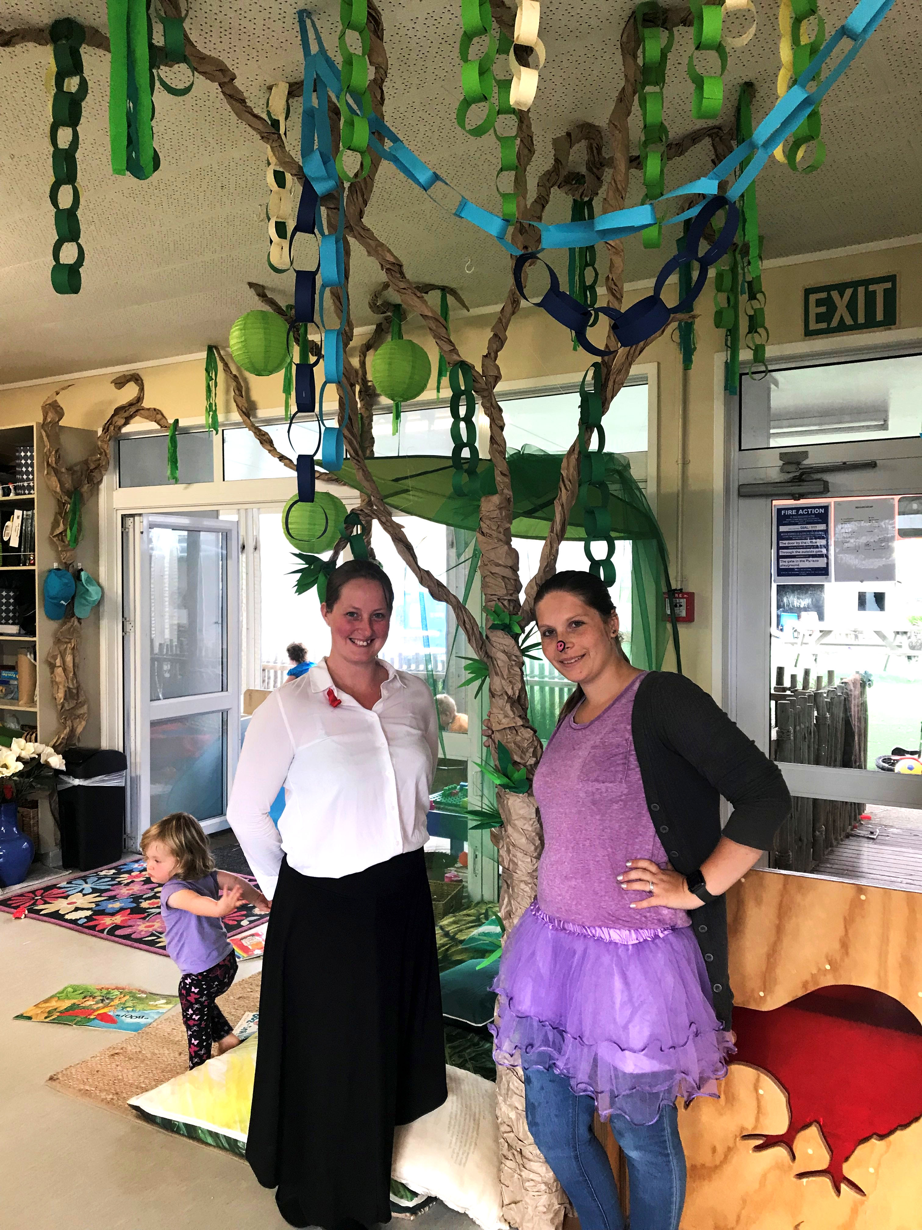 The teachers are posing with their beautiful tree, dressed up as Mary Poppins and as one of the three little pigs for World Story Telling Day.