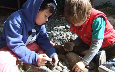 boys exploring stones and wood at daycare