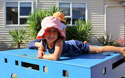 girl on playground equipment at childcare
