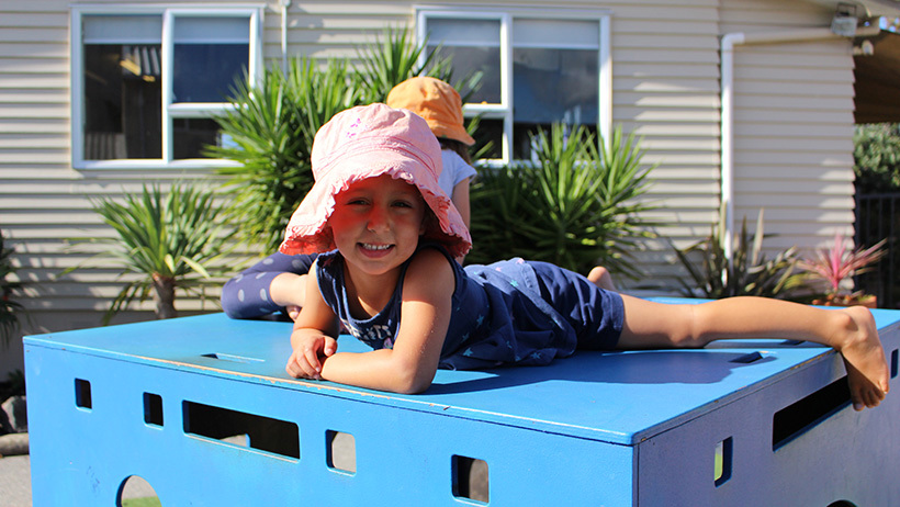 girl on playground equipment at childcare